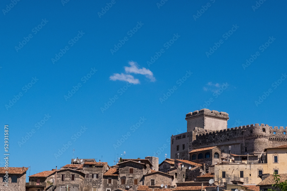 Low angle view of houses on mountain against blue sky during sunny day Low angle view of houses on mountain against blue sky during sunny day