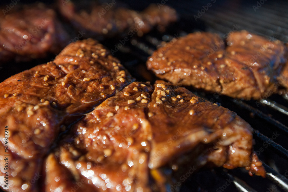 High angle close-up of beef cooking on barbecue High angle close-up of beef cooking on barbecue