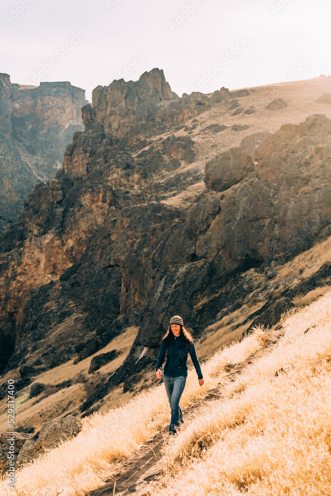 Woman hiking on trail in rocky landscape Woman hiking on trail in rocky landscape