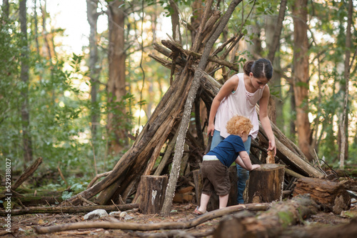 Brother and sister building a fort in the Woods