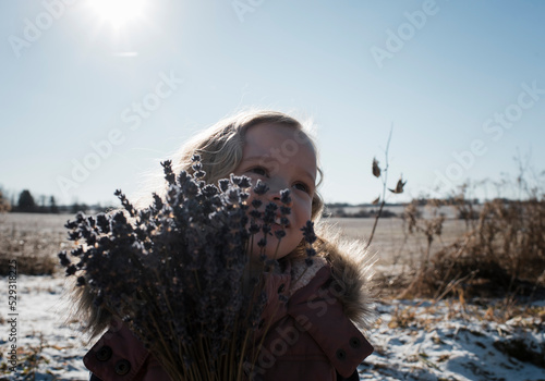 young girl outdoors with a bunch of lavender photo