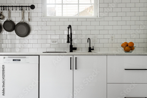 Kitchen sink and white subway tile backsplash photo