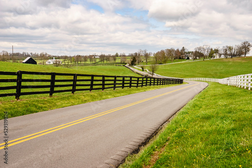Winding two-lane rural road in bluegrass region of Kentucky photo
