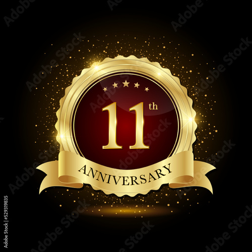 11th golden anniversary logo, with shiny ring and golg ribbon, isolated on black background, vector design