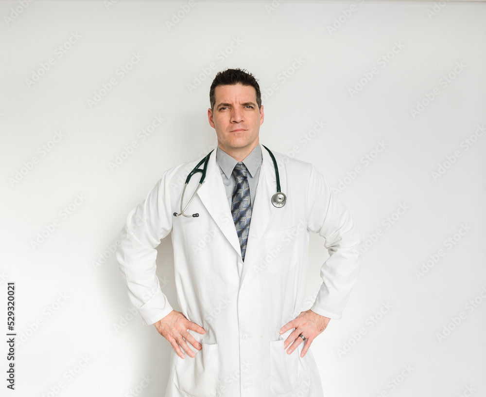 Medical doctor in lab coat standing with hands on hips. Medical doctor in lab coat standing with hands on hips.