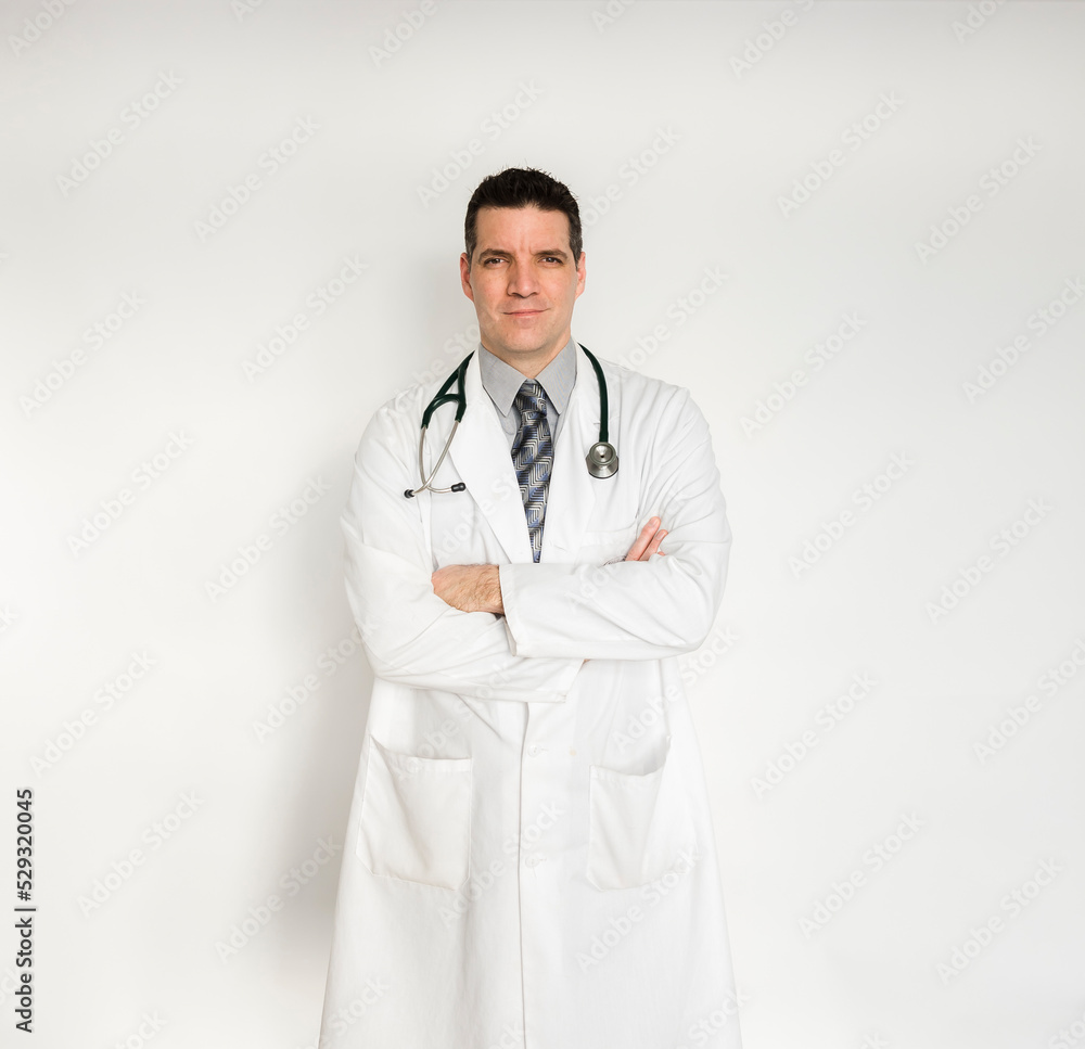 Medical doctor in white coat standing with arms folded. Medical doctor in white coat standing with arms folded.