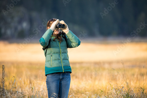 Young woman bird watching with binoculars photo