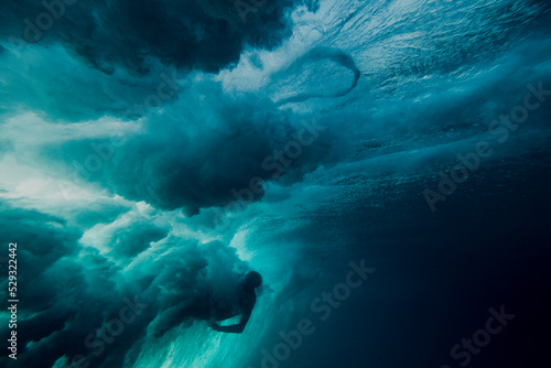 Underwater view of a surfer being wiped out by a powerful wave