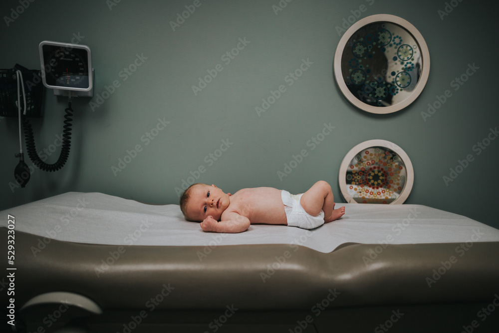 © Cavan Images - Baby boy on exam table at doctors office