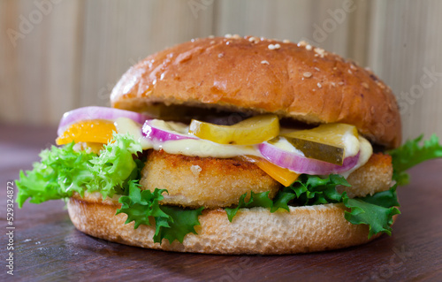 Delicious tasty burger with chicken cutlet, vegetables and cheese at plate