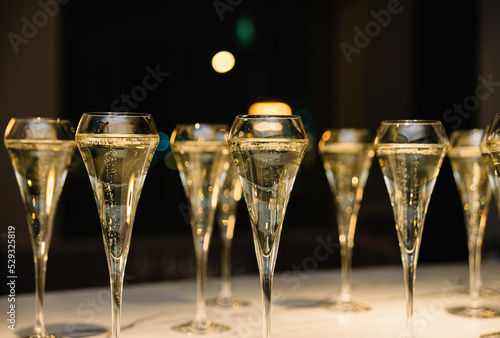 set of champagne glasses on table top  golden light bubbly fine wining in a restaurant 