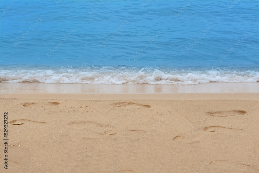 Sandy beach with footprints near beautiful sea