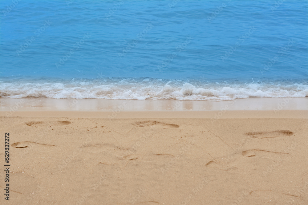 Sandy beach with footprints near beautiful sea Sandy beach with footprints near beautiful sea