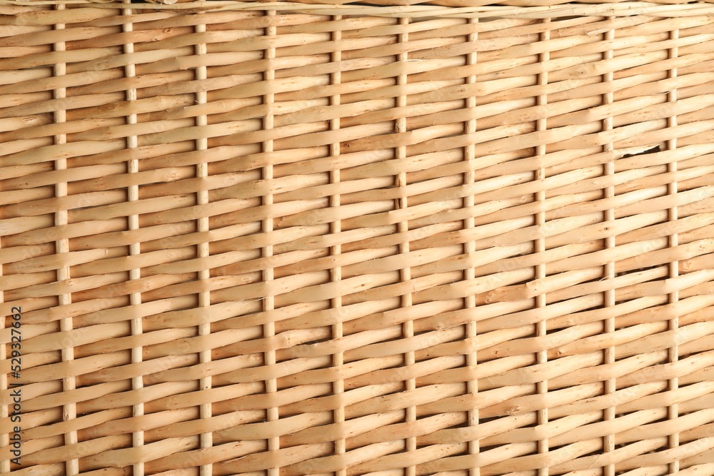 Handmade wicker basket made of natural material as background, closeup view Handmade wicker basket made of natural material as background, closeup view