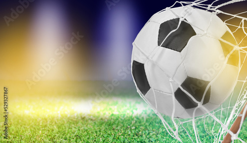 Soccer ball in net and football field on color background  space for text