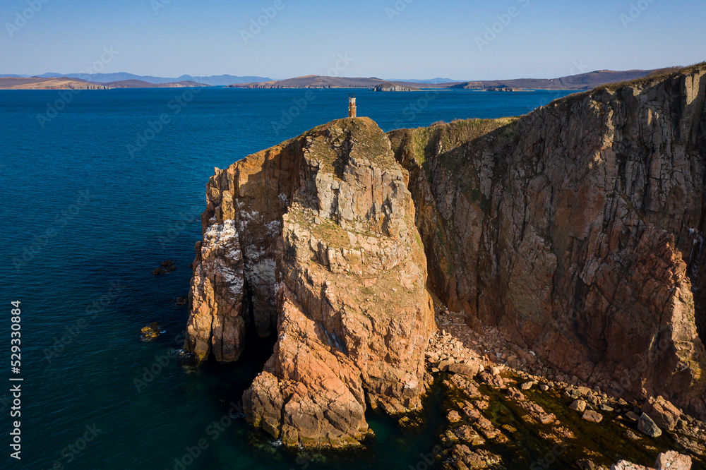 Two sea stacks in the sea. Abandoned lighthouse on top of a rocky island Two sea stacks in the sea. Abandoned lighthouse on top of a rocky island