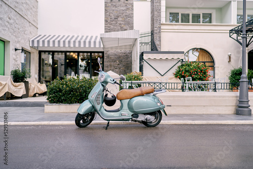 Motor scooter parked near a multi-storey building. High quality photo