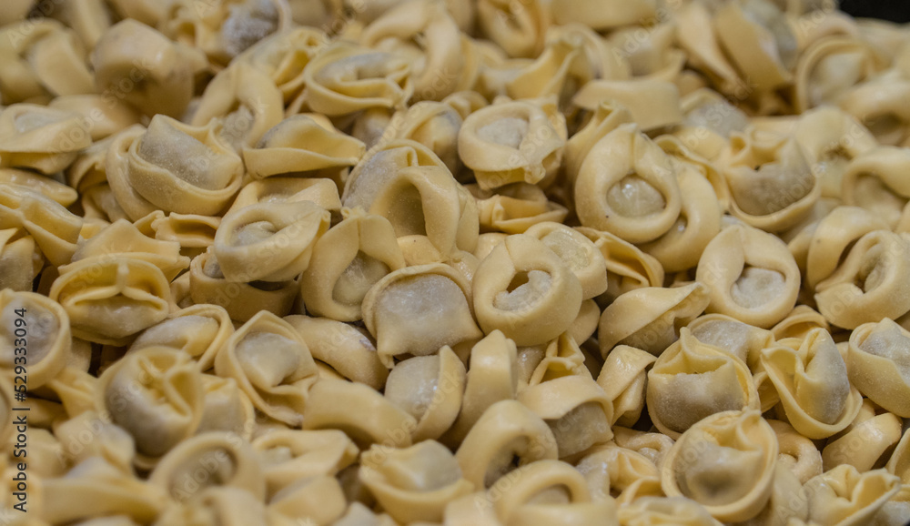 Close up view of ready to cook yellow color tortellini filled with meat at an Italian market Close up view of ready to cook yellow color tortellini filled with meat at an Italian market
