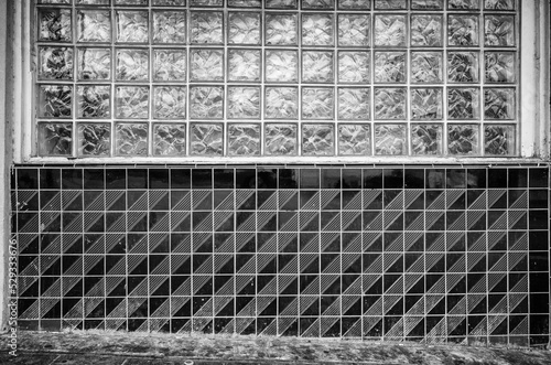 Decaying Art Deco Tiled Wall with Glass Cube Translucent Window in Black and White.