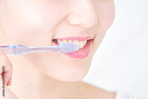 歯磨きする女性のクローズアップ 白背景