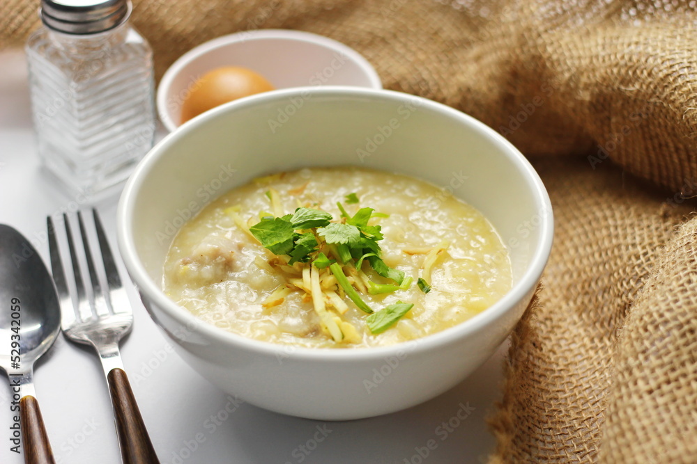 Asian congee with minced pork in white bowl. Asian congee with minced pork in white bowl.