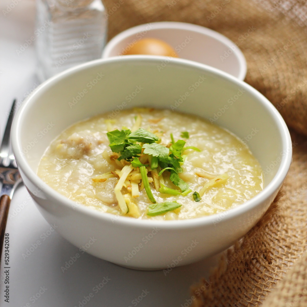 Asian congee with minced pork in white bowl. Asian congee with minced pork in white bowl.