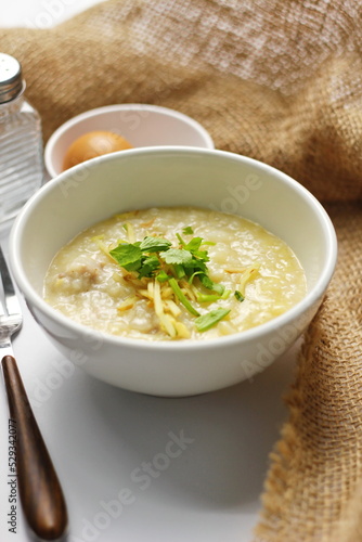 Asian congee with minced pork in white bowl.