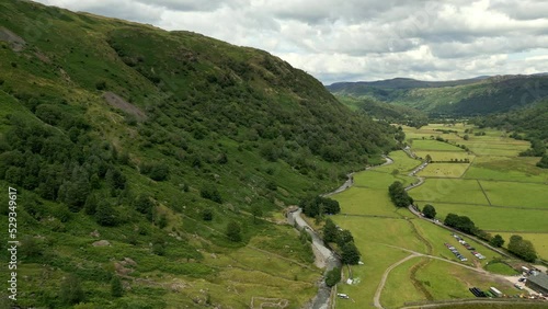 Amazing breathtaking aerial view of Cumbrian valley in the Lake District. Drone footage of green meadows. Dramatic background with hills road. photo