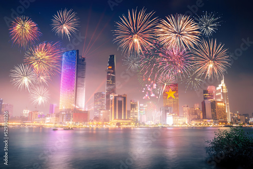 Celebration. Skyline with fireworks light up sky over business district in Ho Chi Minh City ( Saigon ), Vietnam. Beautiful night view cityscape. Holidays, independence day, New Year and Tet holiday #529350226
