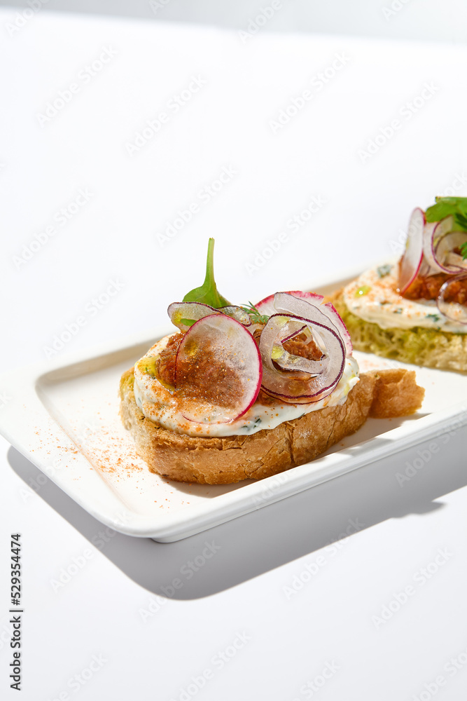 Aesthetic composition with tomato bruschetta on white background with harsh shadows. Italian bruschetta with tomatoes and cheese on fine dining in summer. Elegant menu concept.