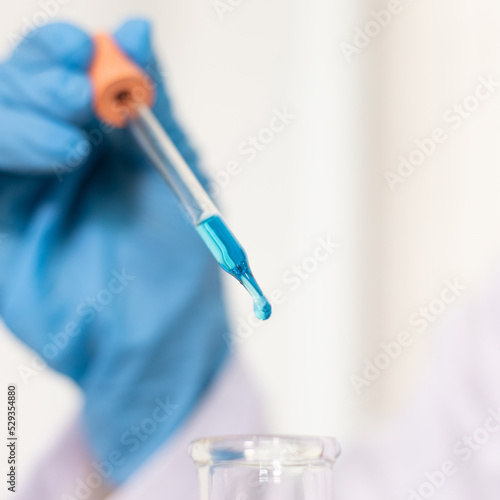 Scientists are carrying blue chemical test tubes to prepare for the determination of chemical composition and biological mass in a scientific laboratory  Scientists and research in the lab Concept.