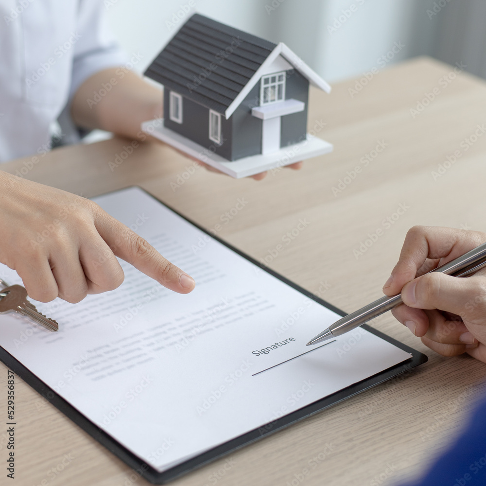 Fototapeta premium Contract signing, Home broker or salesperson allows customers to sign a contract to purchase a home as a legitimate homeowner. Transfer of ownership