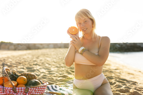 Cheerful young woman enjoy at tropical sand beach. Young woman having a picnic on the beach. photo