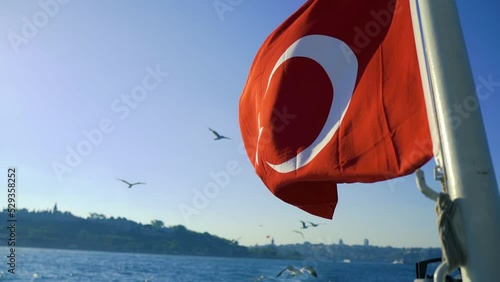 Flying Turkish  Flag on blue sky background, waving in the wind. photo