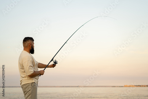 Summer fishing on the lake man with fishing rod, hobby and leisure outdoors, fishing