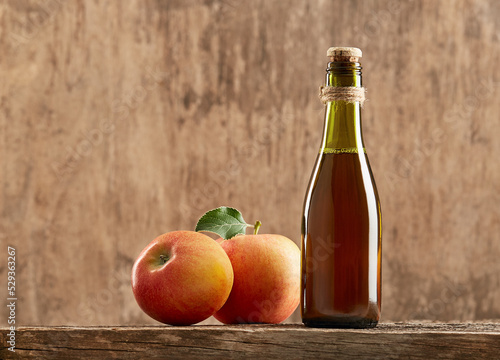 Apple vinegar cider with apple fruit on old wooden background.
