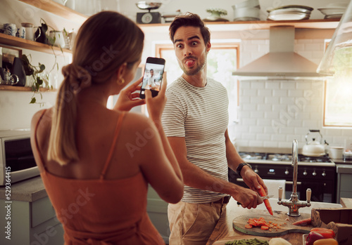 Tableau sur toile Cooking man sticking out tongue to make silly, goofy and funny face to pose for a photo while making food in the kitchen at home