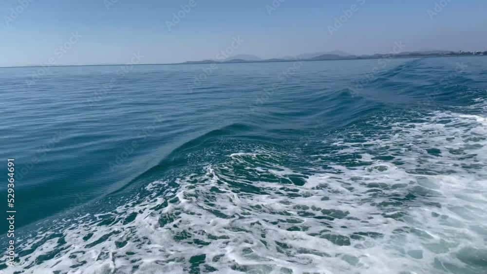 Wake of back view vessel over the water's surface in sea. Speed boat floating in the ocean. Wake of back view vessel over the water's surface in sea. Speed boat floating in the ocean.