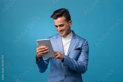 Young happy handsome man in business suit and tablet