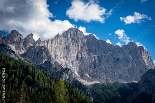 clouds over the mountains dolomiti, with blue sky and green trees in italy © Vincenzo H. Langone