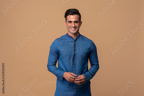 Young handsome Indian man wearing kurta with gifts in hand