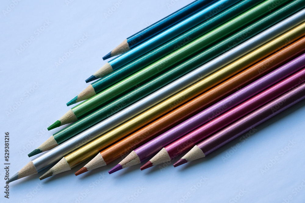Fototapeta premium Colored pencils with a metallic sheen close-up. Background with place for text. High quality photo