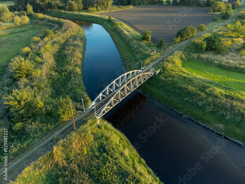 Old steel tram bridge over the Ner River in the city of Lutomiersk, Poland. photo