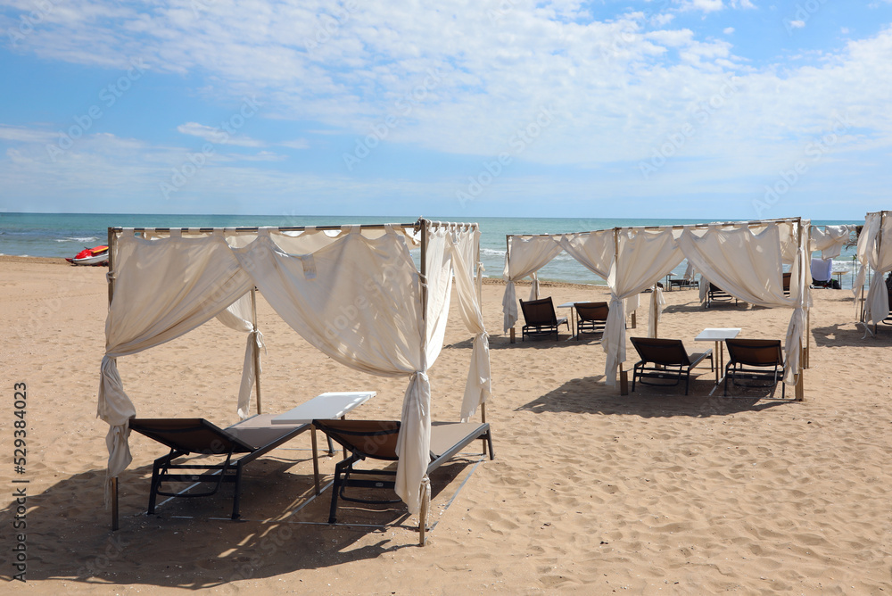 gazebos to shelter from the sun with deckchairs in the exclusive resort by the sea in summer