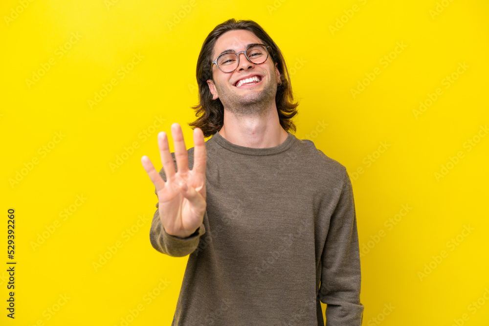 Caucasian handsome man isolated on yellow background happy and counting four with fingers Caucasian handsome man isolated on yellow background happy and counting four with fingers