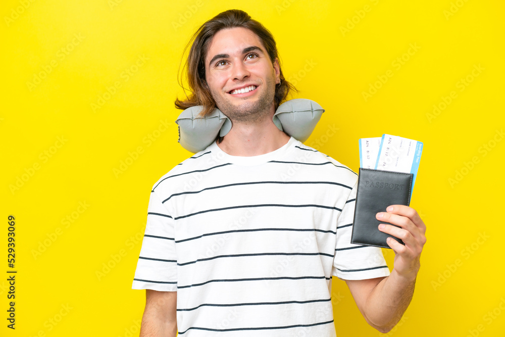 handsome Man with Inflatable Travel Pillow thinking an idea while looking up handsome Man with Inflatable Travel Pillow thinking an idea while looking up