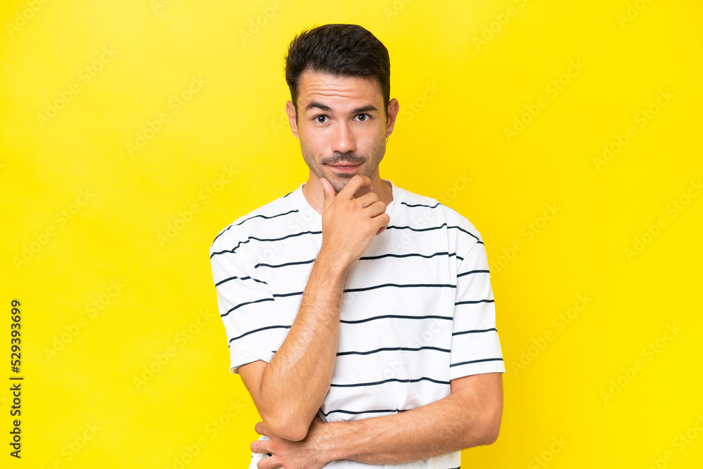 Young handsome man over isolated yellow background thinking Young handsome man over isolated yellow background thinking