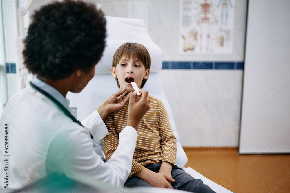 Little boy during throat examination at pediatrician's office. Little boy during throat examination at pediatrician's office.