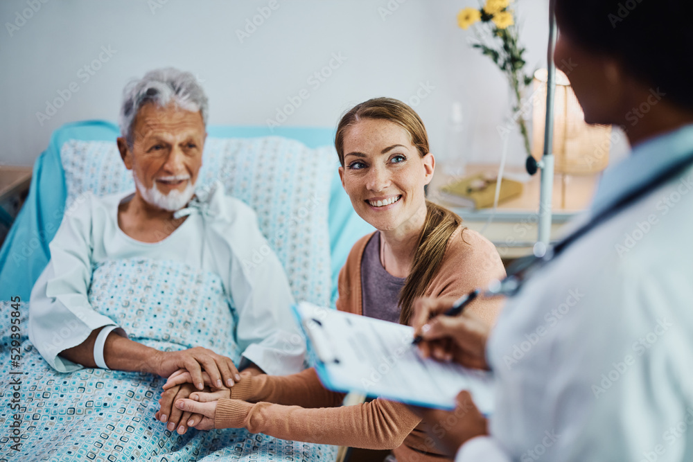 Happy woman and her hospitalized father talking to doctor at clinic. Happy woman and her hospitalized father talking to doctor at clinic.