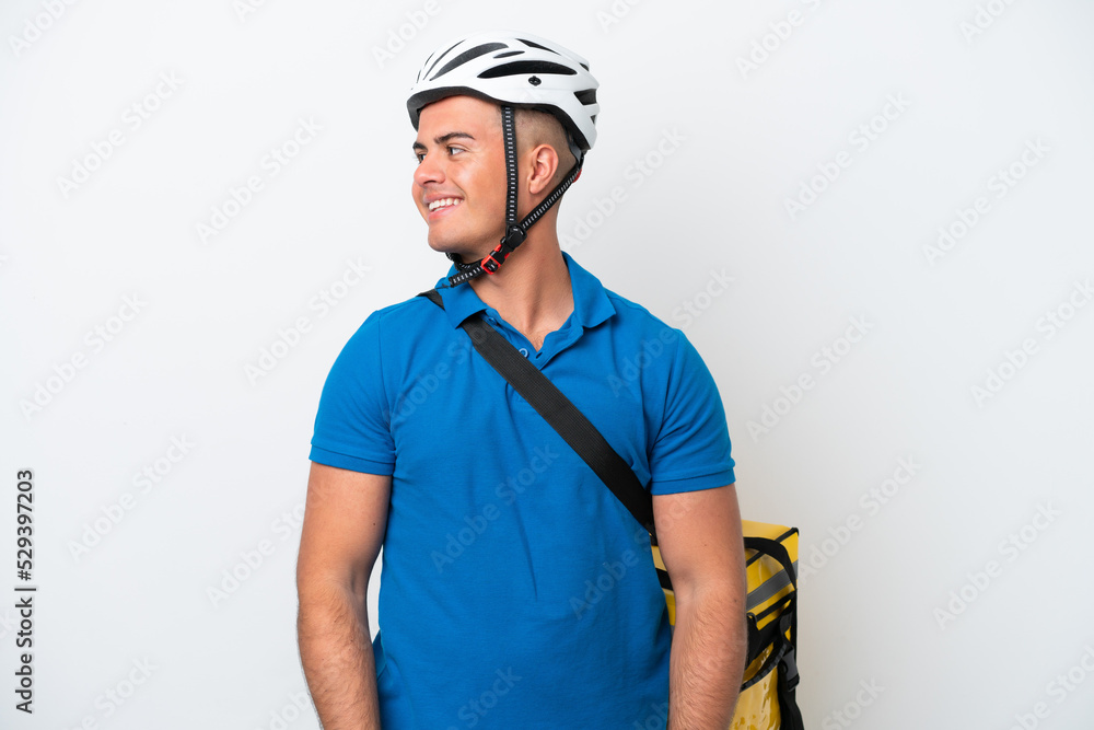 Young caucasian man with thermal backpack isolated on white background looking side Young caucasian man with thermal backpack isolated on white background looking side
